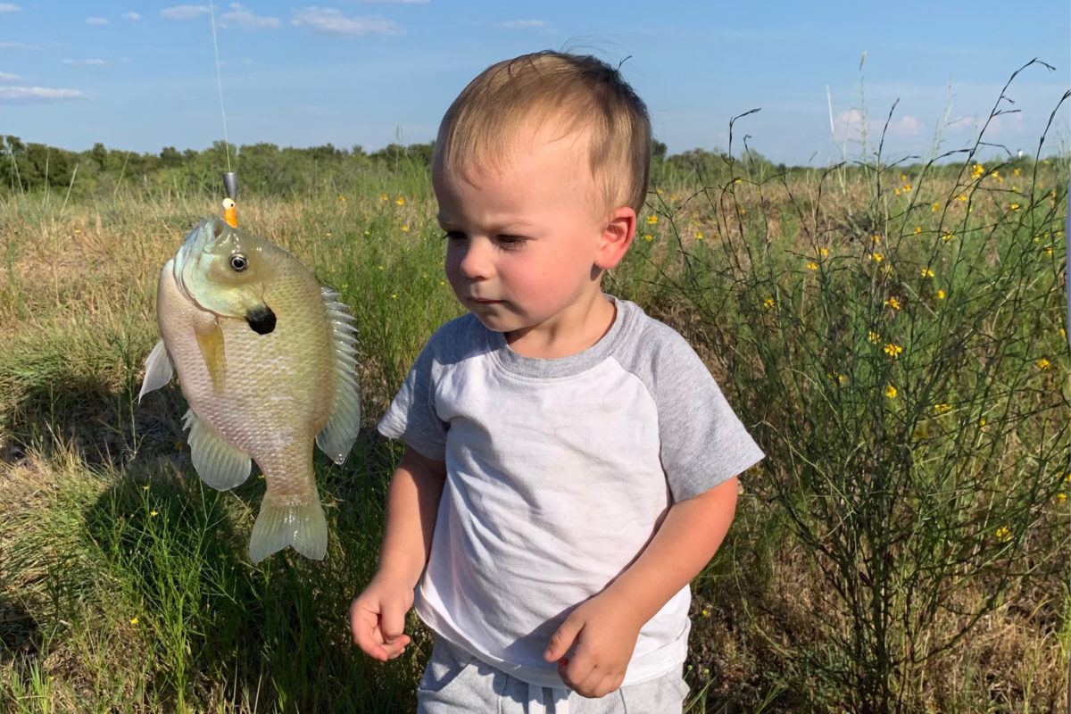 Adorable little boy caught his first fish on the Austin Trophy Whitetails ranch.