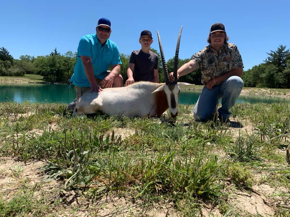 Three hunters with a successful hunt at the hunting ranch in Texas.