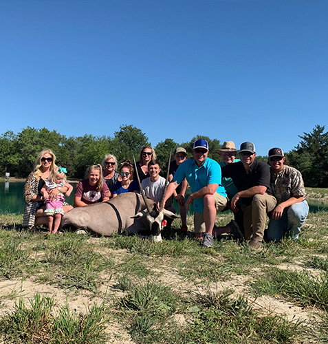 An entire family surrounding their trophy animal at the hunting ranch in Shiner, Texas.